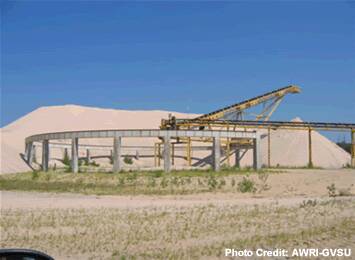 A sand mining facility with a dune in the background.
